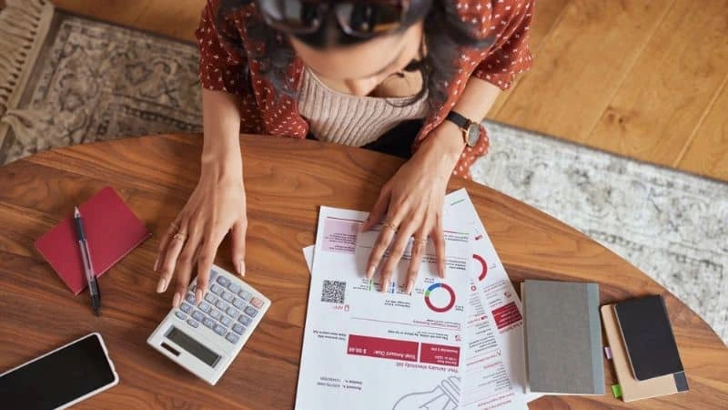 Mesa organizada com boletos e utensílios para controle financeiro doméstico — organização traz tranquilidade.
