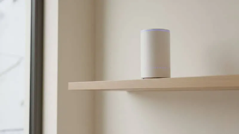 Uma foto de um roteador em cima de uma prateleira alta e limpa.